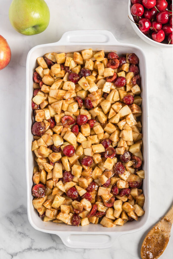 Cherries and Apples with sugar in a casserole dish
